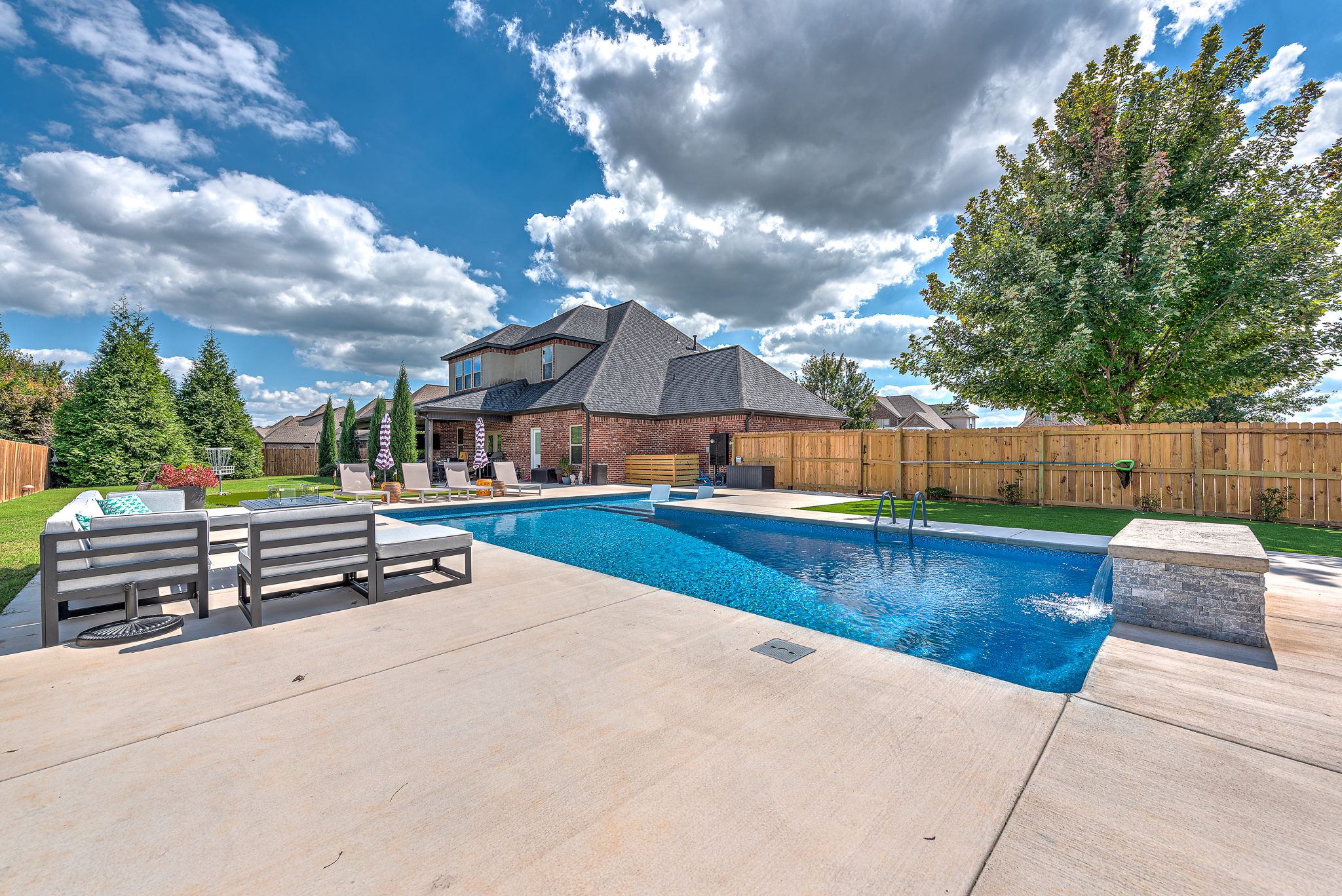 Custom pool with deck jets and water features by Saltscapes NWA