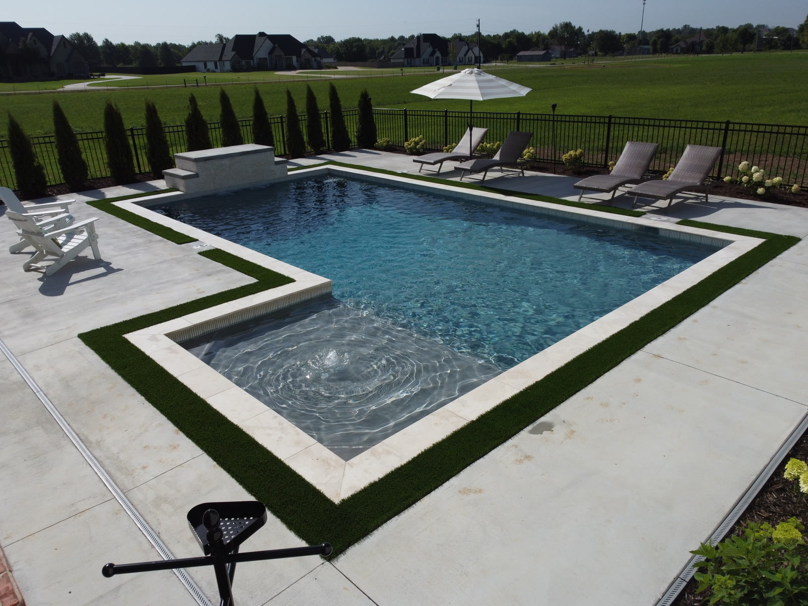Custom inground pool with sun-sparkled water and spa tanning ledge - Northwest Arkansas
