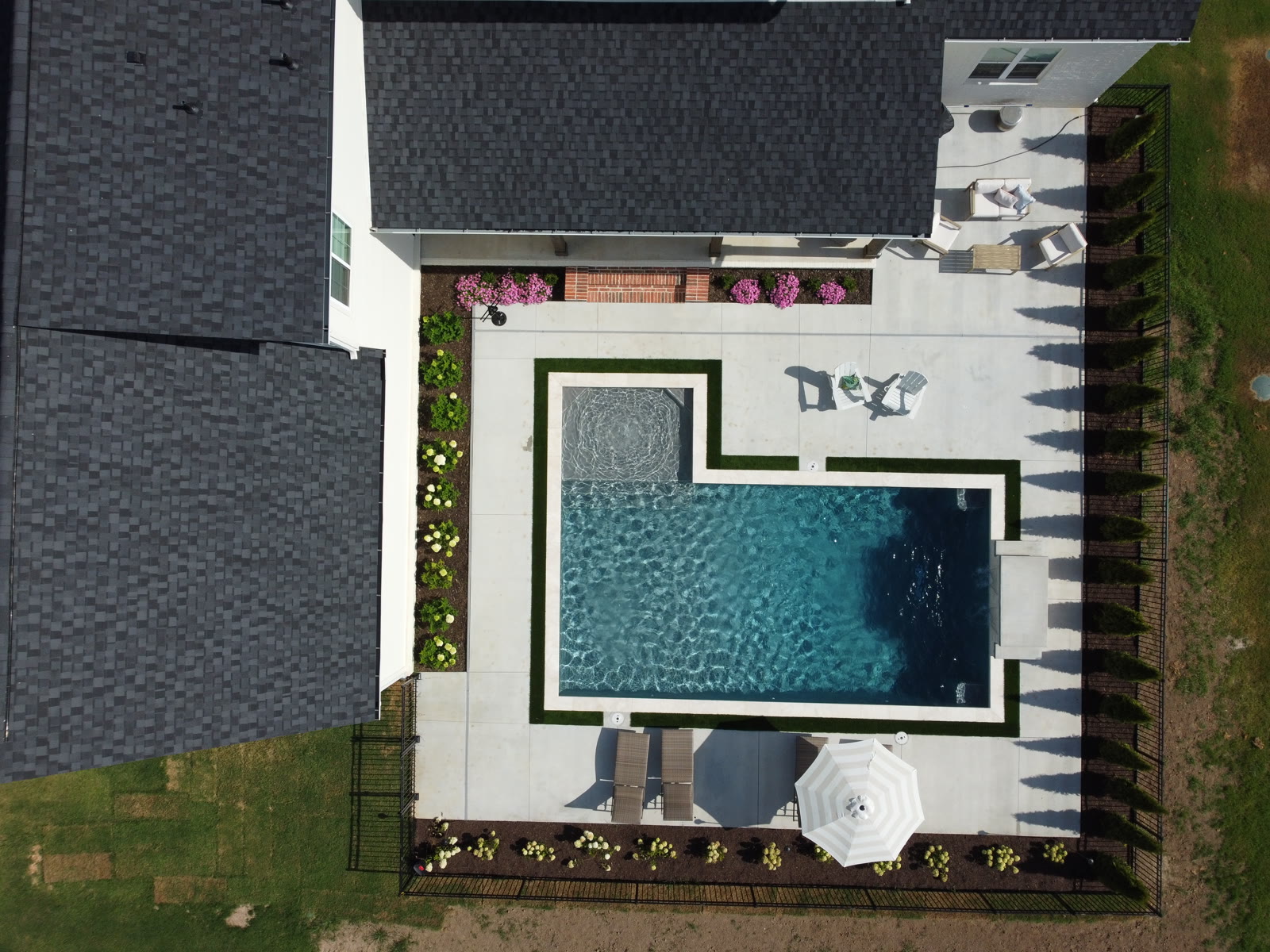 Top-down aerial of custom L-shaped inground pool with tanning ledge - Northwest Arkansas