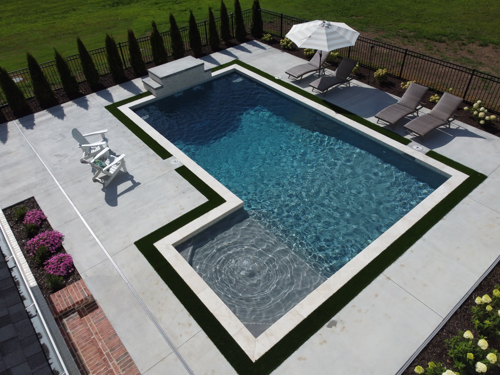 Custom pool with circular spa water feature and premium hardscape - Saltscapes NWA